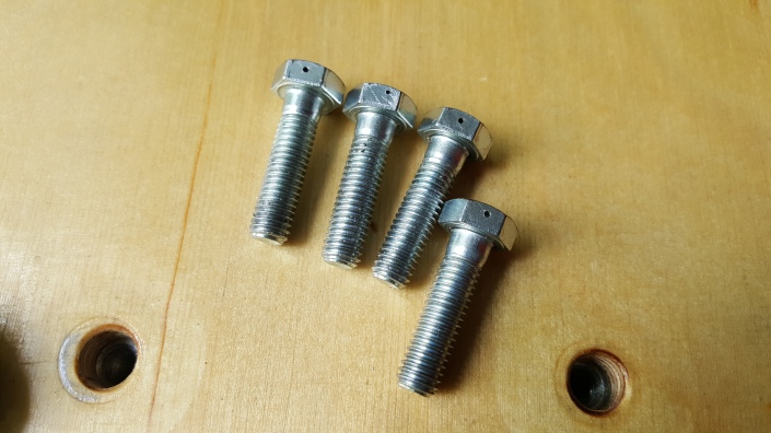 Drilled heads in engine bolts